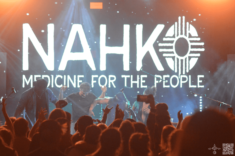 Nahko Bear and Band on Stage, Holding Hands and Taking a Bow. End of Performance.